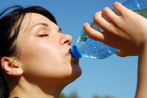 plastik şişeden su içen kadın