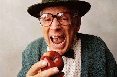 elmayı ısırmak üzere olan yaşlı şapkalı gözlüklü adam