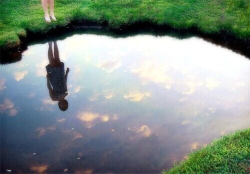 gölde yansımasına bakan kadın