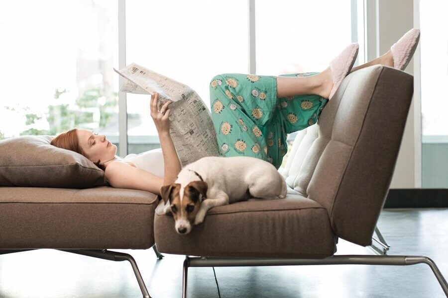 uzanarak gazete okuyan kadın ve köpeği