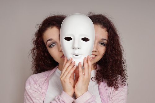 maske arkasında gülen ve somurtan genç