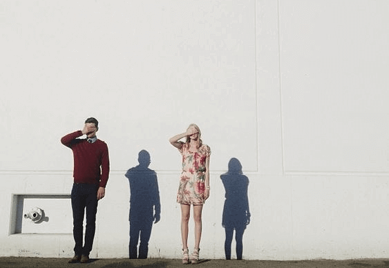 gözlerini kapatmış duvarın önünde duran kadın ve erkek