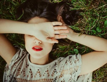 çimlerde uzanmış gözleri kapalı kadın