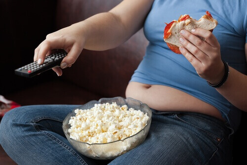 televizyon karşısında kontrolsüzce yemek yiyen kadın