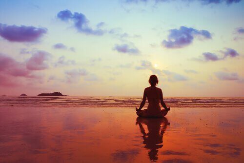 sahilde meditasyon yapan kadın