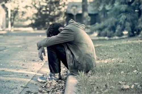 yol kenarında oturan yalnız çocuk