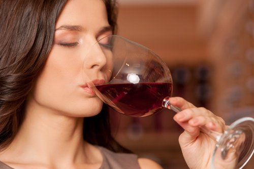 bir kadeh kırmızı şarap içen kadın