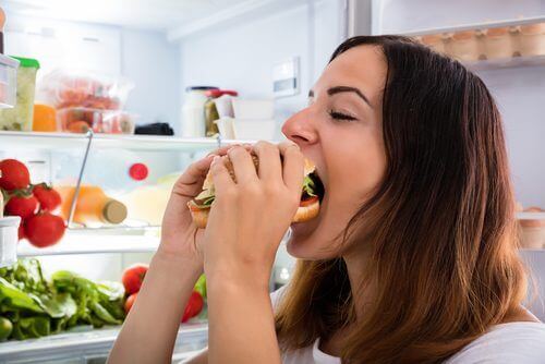 buzdolabı önünde yiyen kadın
