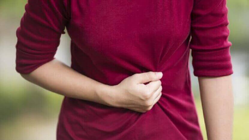 karnı ağrıyan kadın