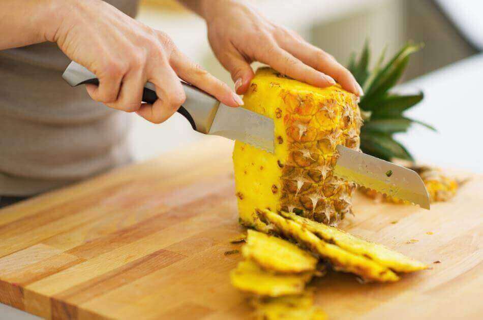 ananasın kabukları bıçakla kesilirken