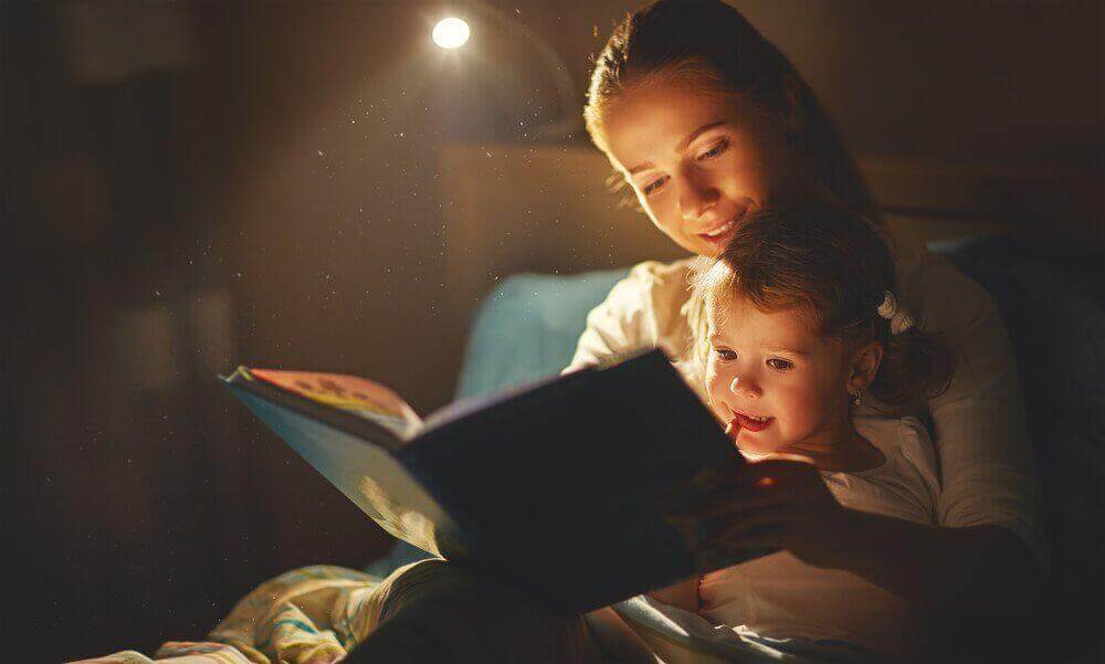 uyku vakti çocuğuna masal okuyan anne