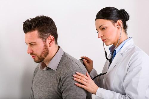 hastanın sırtını dinleyen kadın doktor