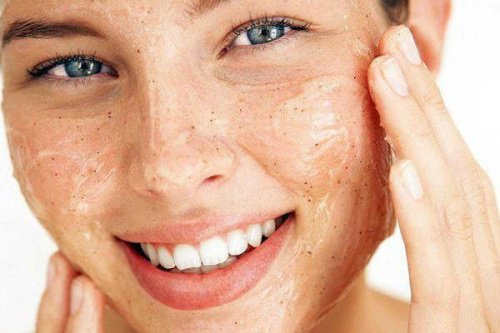 yüzüne peeling yapan mutlu kadın