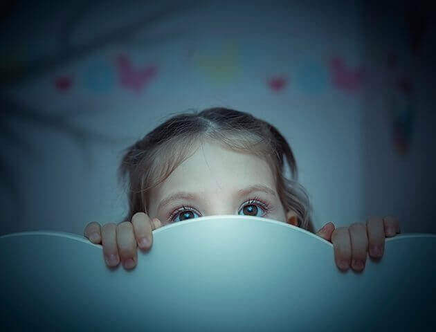 çocuk yataktan bakıyor korkmuş