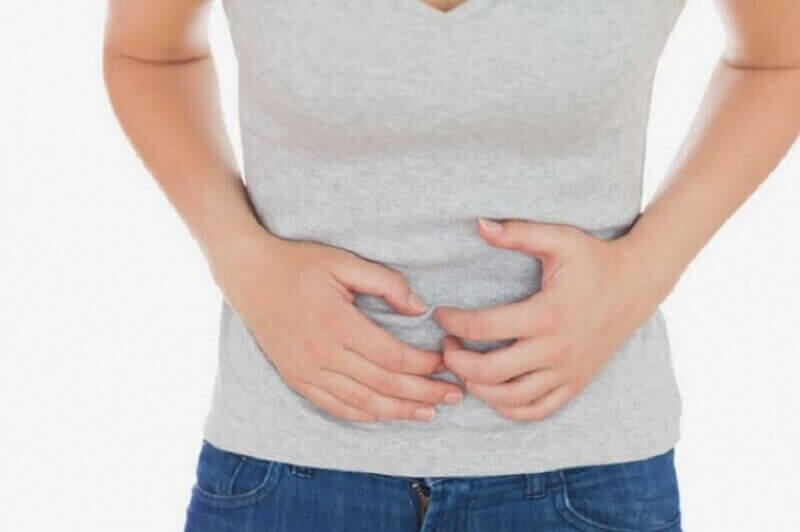 hazımsızlık yüzünden karnını tutan kadın