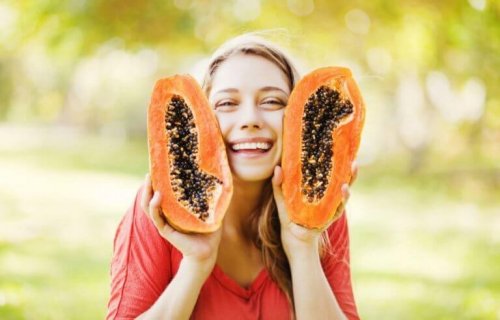 elinde ikiye bölünmüş papaya tutan kadın