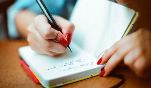 deftere yazı yazan kadın eli