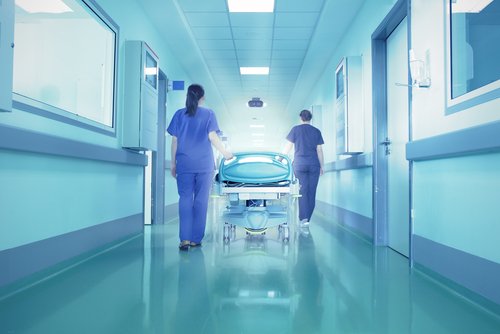 hastanede yatak taşıyan doktorlar