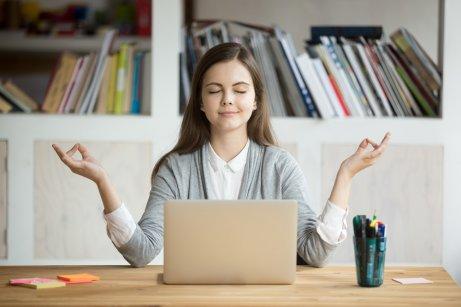bilgisayar başında meditasyon yaparak stresi yöneten kadın