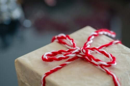 Kırmızı beyaz kurdeleli bir hediye kutusu.