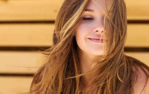 saçları uçuşan gülümseyen kadın sağlıklı bir saç derisi