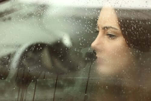 yağmurlu araba camından bakan kadın