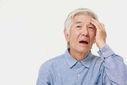 başını tutan yaşlı adam