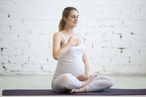 Yoga yapan hamile bir kadın.