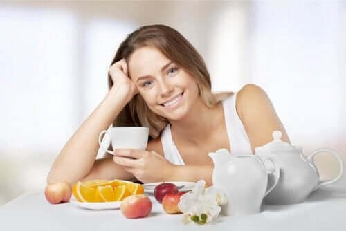 Meyve yiyen ve çay içen kadın