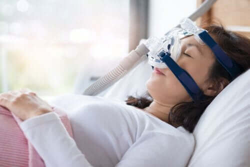 CPAP makinesine bağlı bir şekilde uyuyan kadın