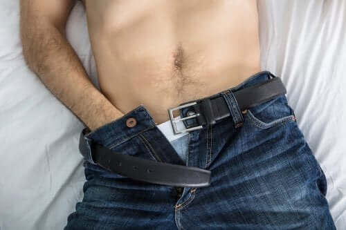 Elini pantolonunun içine sokmuş bir adam.