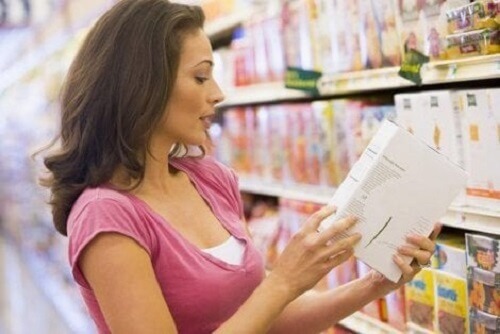 Markette bir gıda etiketi okuyan bir kadın.