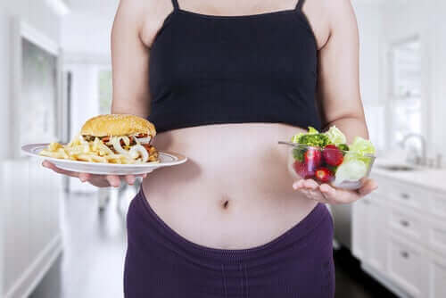 Yiyecekler arasında karar vermeye çalışan hamile kadın
