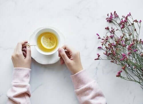 masada limon çayı ve çay fincanını tutan eller