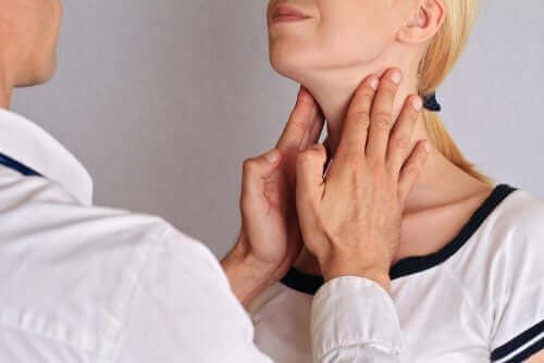 Bir kadının tiroit bezlerini muayene eden bir doktor.