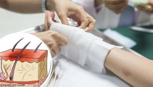 Bir kişinin bandajını değiştiren bir doktor.