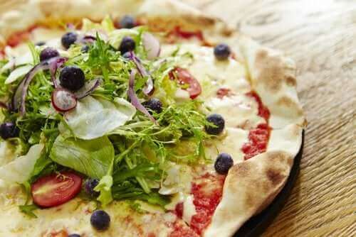 Üzerinde marul olan bir pizza.