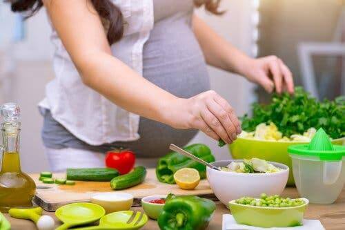 Salata hazırlayan bir hamile kadın.