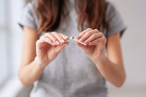 Elindeki sigarayı kıran bir kadın.
