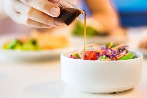 Salatasının üstüne sos döken bir kişi.