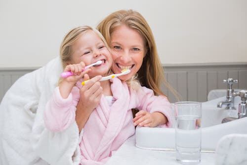 Dişlerini fırçalayan bir anne ve kız çocuğu.