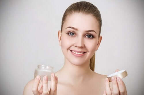Elinde cilt beyazlatıcı krem tutan bir kadın.