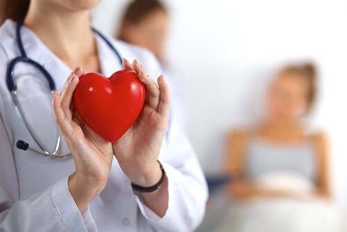 Elinde bir kalp tutan bir doktor.