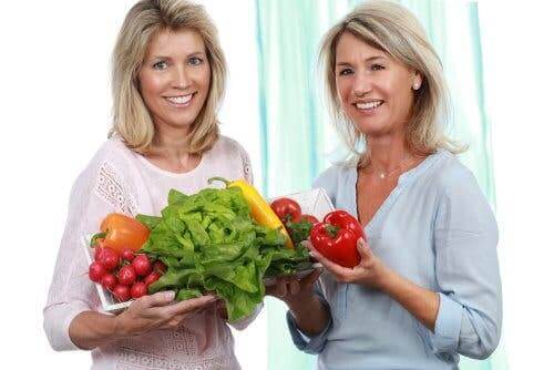 Ellerinde sağlıklı sebzeler tutan iki kadın.