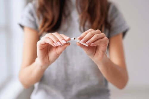 Kanseri önlemek için elindeki sigarayı kıran bir kadın.