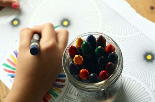 Küçük bir çocuk boya kalemleri ile resim yapıyor