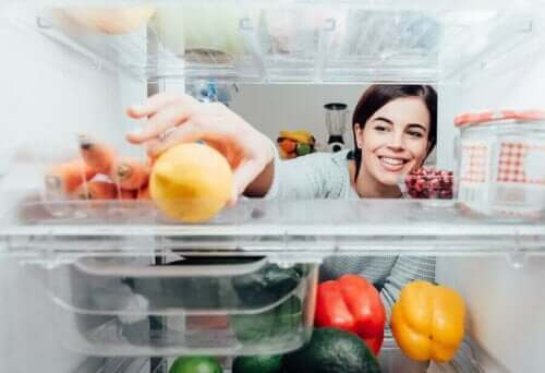Buzdolabının içinden bir şeyler alan bir kadın.
