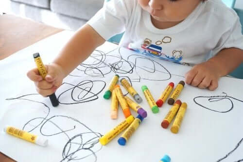 küçük çocuk boya kalemleriyle resim yapıyor
