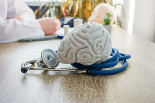 Bir doktorun masasında duran bir beyin modeli.
