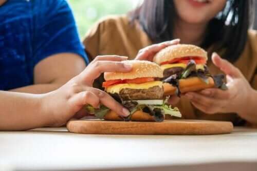 Hamburger yiyen iki kişi.